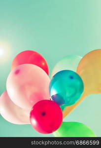Multicolored balloons in the sun on the sky background, vintage toning