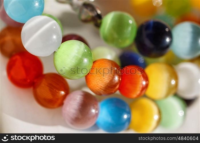 Multicolored bright glass beads on white background