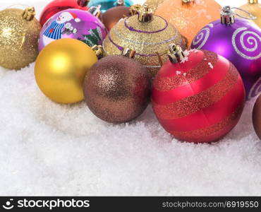 Multicolored Christmas balls in the snow. new year background
