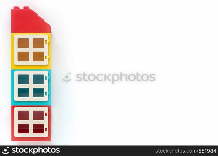 Multicolored House of plastic constructor bricks on white background. Popular toys. Free space for text. House of plastic constructor bricks on white background. Popular toys. Free space for text