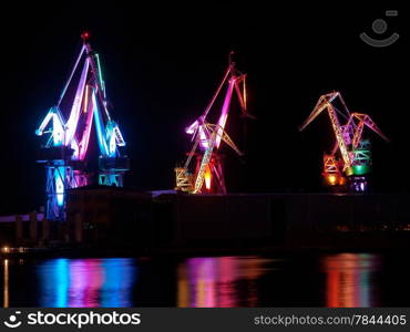 multicolored illumination of shipyard cranes, led lights, night shot