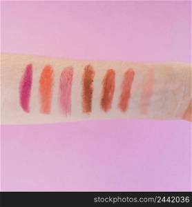 multicolored lipstick shades female s hand pink background