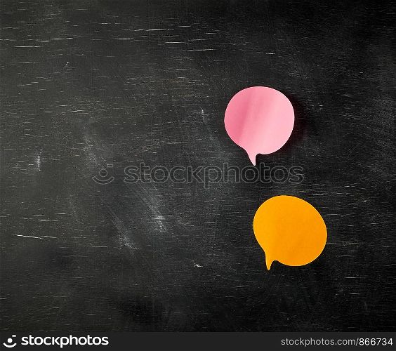 multicolored paper stickers on a black background in the shape of a cloud, copy space