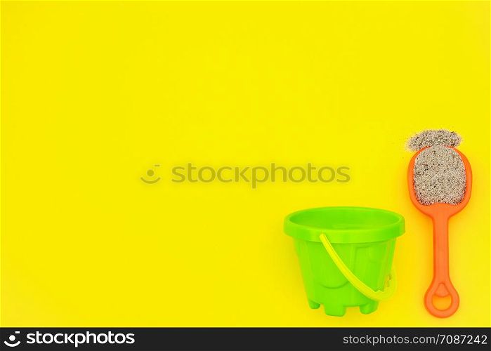Multicolored set children&rsquo;s toys for summer games in sandbox or on sandy beach on yellow background with copy space. Creative top view Flat lay Concept. Template for your text or design.. Multicolored set children&rsquo;s toys for summer games in sandbox or on sandy beach on yellow background with copy space. Top view Flat lay Concept. Template for your text or design