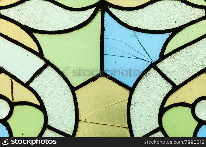 multicolored stained glass window with irregular block pattern in hue of blue green