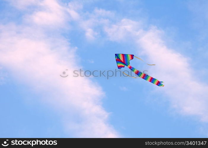 multicolored striped kite flying in the blue sky