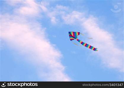 multicolored striped kite flying in the blue sky