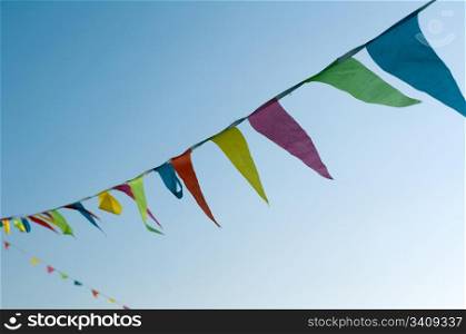 Multicolored striped triangular flags on a rope