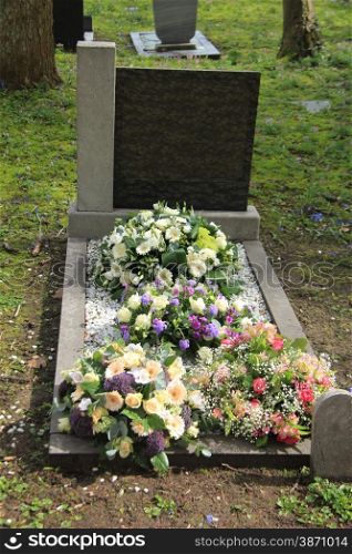 Multicolored sympathy flowers on an old grave