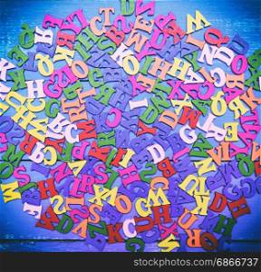 Multicolored wooden letters of the English alphabet blue background