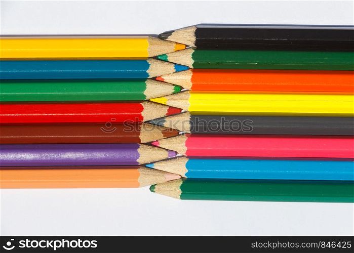 Multicolored wooden pencils interwoven on white background