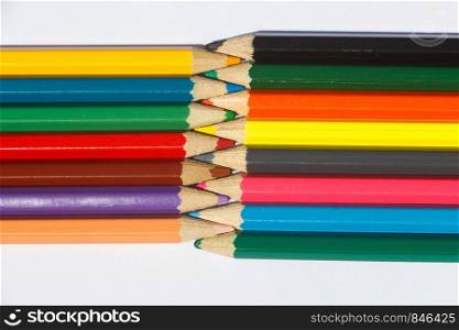 Multicolored wooden pencils interwoven on white background