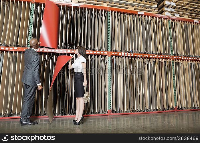 Multiethnic business coworkers selecting thin red veneer sheets