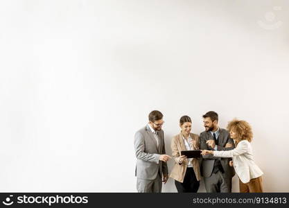 Multiethnic business people using digital tablet while standing by the wall in the modern office