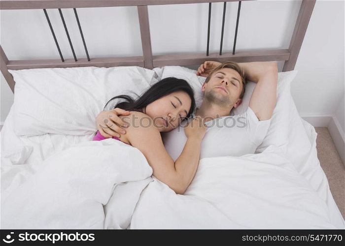 Multiethnic couple sleeping in bed