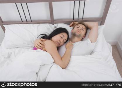 Multiethnic couple sleeping in bed