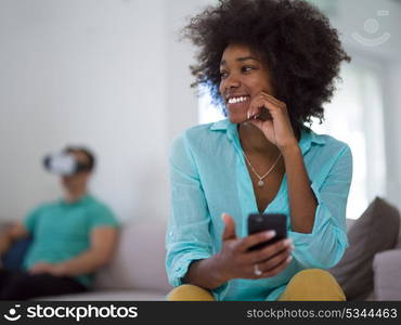 Multiethnic Couple using virtual reality headset in living room at home people playing game with new trends technology