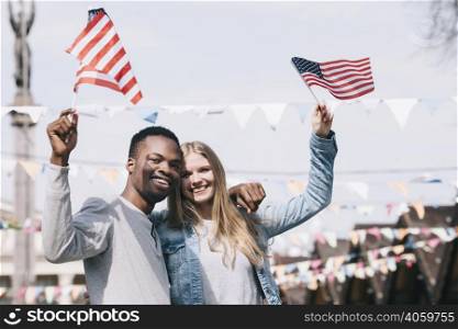 multiethnic friends holding american flags outstretched hands