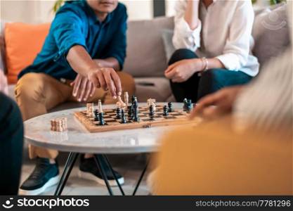 Multiethnic group of businesspeople playing chess while having a break in relaxation area at modern startup office. Selective focus. High-quality photo. Multiethnic group of business people playing chess while having a break in relaxation area at modern startup office. Selective focus 