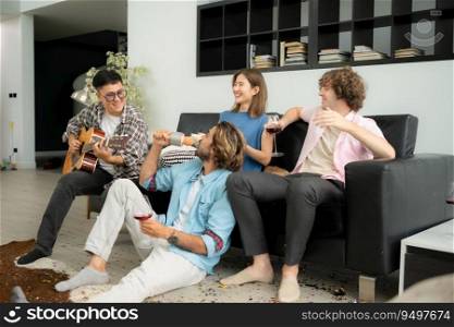 Multiethnic group of friends having fun playing guitar and singing together at home