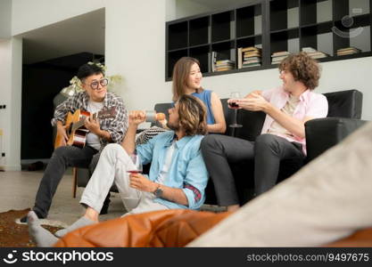 Multiethnic group of friends having fun playing guitar and singing together at home