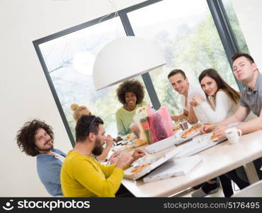 multiethnic group of happy friends spending time together with food and soda drinks, eating at home concept