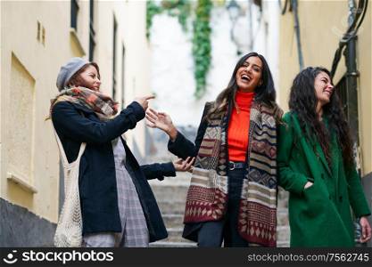 Multiethnic group of three happy woman walking in urban background. Multiethnic group of three happy woman walking together outdoors