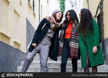 Multiethnic group of three happy woman walking in urban background. Multiethnic group of three happy woman walking together outdoors