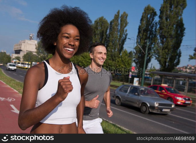 multiethnic group of young people on the jogging beautiful morning as the sun rises in the streets of the city