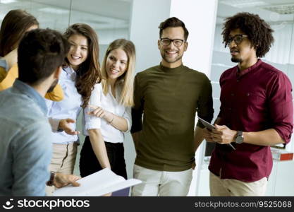 Multiethnic group of young people standing in modern office and brainstorming