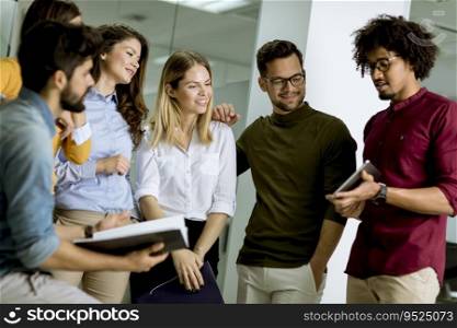 Multiethnic group of young people standing in modern office and brainstorming