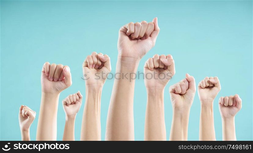 Multiethnic male and female hand raised against a blue background