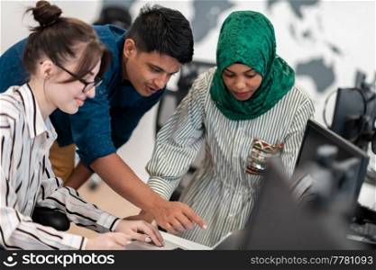 Multiethnic startup business team Arabian woman wearing a hijab on meeting in modern open plan office interior brainstorming, working on laptop and desktop computer. Selective focus. High-quality photo. Multiethnic startup business team Arabian woman wearing a hijab on meeting in modern open plan office interior brainstorming, working on laptop and desktop computer. Selective focus 