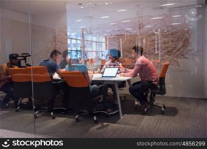Multiethnic startup business team on meeting in modern bright office interior brainstorming, working on laptop and tablet computer