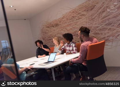 Multiethnic startup business team on meeting in modern bright office interior brainstorming, working on laptop and tablet computer