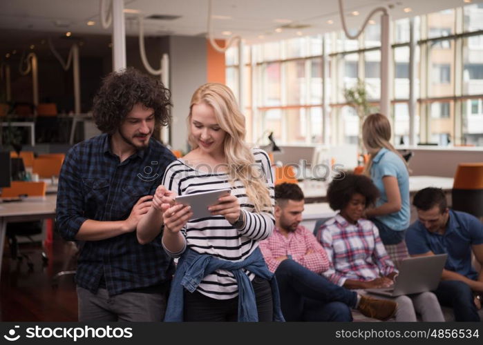 Multiethnic startup business team on meeting in modern bright office interior brainstorming, working on laptop and tablet computer two in front of the other