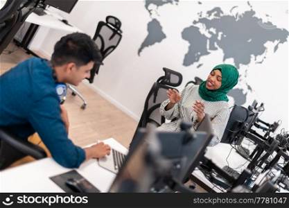 Multiethnic startup business team woman wearing a hijab on meeting in modern open plan office interior brainstorming, working on laptop and desktop computer. Selective focus. High-quality photo. Multiethnic startup business team woman wearing a hijab on meeting in modern open plan office interior brainstorming, working on laptop and desktop computer. Selective focus