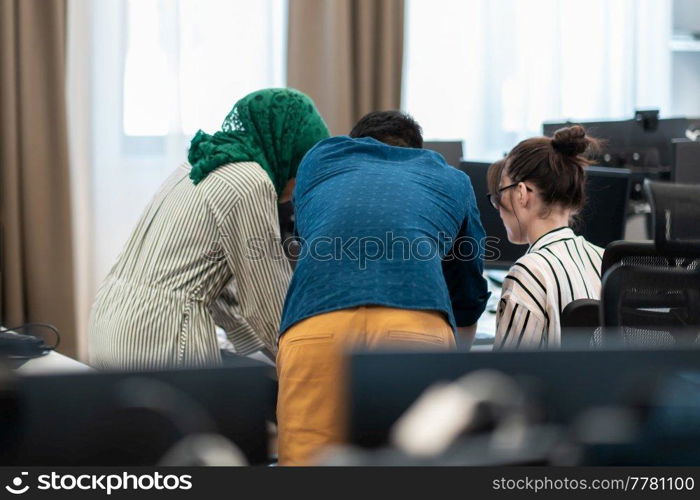 Multiethnic startup business team woman wearing a hijab on meeting in modern open plan office interior brainstorming, working on laptop and desktop computer. Selective focus. High-quality photo. Multiethnic startup business team woman wearing a hijab on meeting in modern open plan office interior brainstorming, working on laptop and desktop computer. Selective focus 