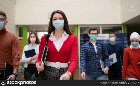 multiethnic students group walking on university coridor wearing protective face mask in new normal coronavirus pandemic lifestyle in education