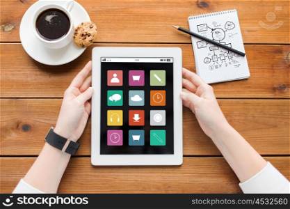 multimedia, business, education, technology and people concept - close up of woman with menu icons on tablet pc computer screen and coffee cup on wooden table