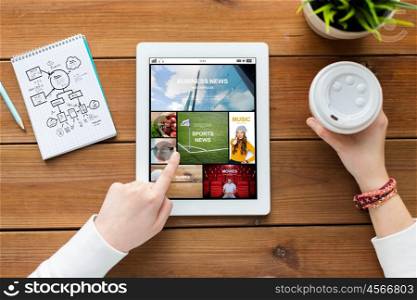 multimedia, business, education, technology and people concept - close up of woman with internet news application on tablet pc computer screen and coffee on wooden table