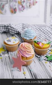 Multiple colorful nicely decorated muffins on a wooden background