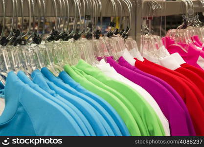 Multiple colors of sprts shirts hang on the rack