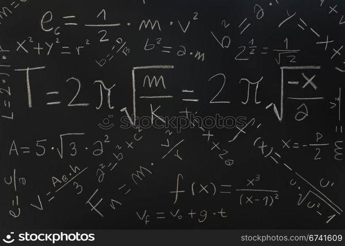 Multiple physical formulas written on a blackboard