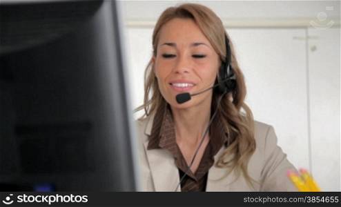 multiple shots of mid adult woman with headset talking on the phone in call center.