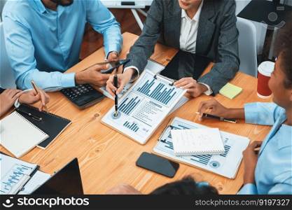 Multiracial analyst team use BI dashboard data to analyze financial report on meeting table. Group of diverse business people utilize data analysis by FIntech for business marketing decision. Concord. Multiracial analyst team use BI dashboard for data analysis. Concord