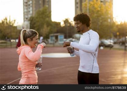 Multiracial couple of young runners resting after training
