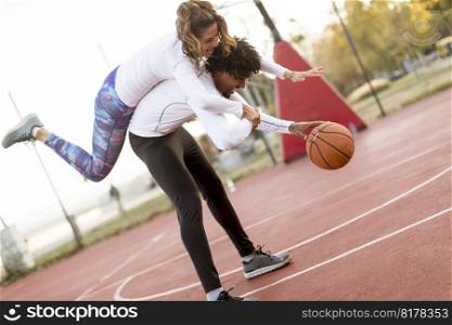 Multiracial couple playing basketball at court
