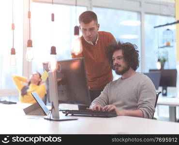 Multiracial creative business people group as freelancers in modern coworking open space office working together as a team on startup project with tablet, smart phone, laptop computer.