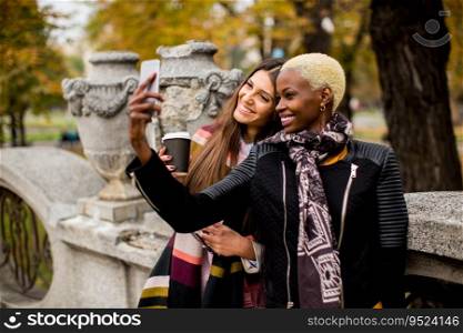 Multiracial female friends taking selfie outdoor